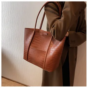 Brown crocodile embossed tote bag styled with a matching coffee blazer on model
