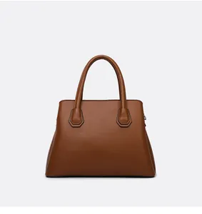 Close-up of brown lychee grain leather tote bag featuring durable handles and hardware