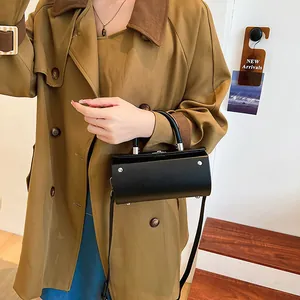 Minimalist black cylinder handbag with silver studs and top handle for modern women