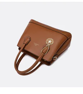 Detail of brown litchi pattern tote bag with golden rose pearl charm and XTJ logo