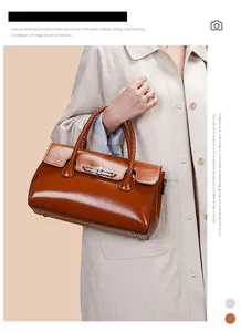 Detail of caramel leather handbag featuring a unique woven handle and metal clasp closure
