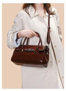 Detail of vintage brown leather handbag featuring woven handle and bamboo metal lock