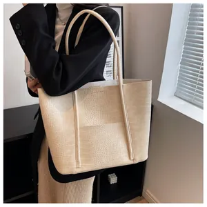 Detail of beige faux crocodile leather texture on a large capacity tote shoulder bag