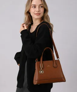 Detail of brown litchi leather tote bag with gold lettering and pearl flower charm