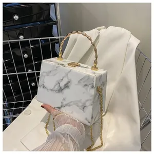 Detail of marble pattern box clutch bag with gold bamboo handle and chain strap