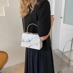 Detail of marble pattern crossbody box bag with gold bamboo handle and chain strap