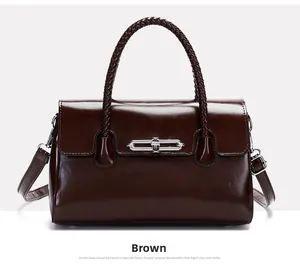 Detailed view of brown leather handbag featuring woven handle and silver metal lock closure