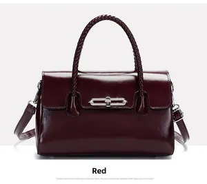 Detail of red glossy leather handbag featuring silver metal bar lock and woven handle