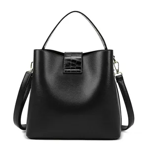 Dettaglio della borsa in pelle nera con motivo litchi e texture a coccodrillo