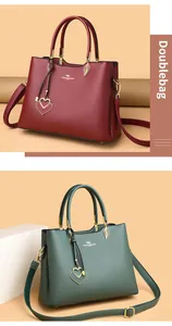 Close-up of textured leather handbags in wine red and dark green with heart charms