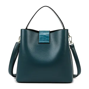 Dettaglio borsa a secchiello in pelle martellata verde scuro con inserto in coccodrillo