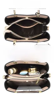 Detail view of multi-compartment interior for beige tote bag with black trim and gold hardware