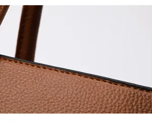 Macro shot of brown pebble leather tote bag with detailed stitching and black oil edges