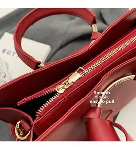 Detail of high-quality smooth golden metal zipper on a premium red bucket handbag