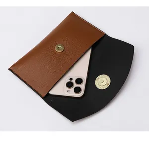 Detail of minimalist two-tone leather phone bag with magnetic closure and pebble texture