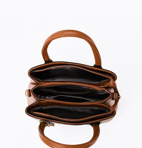 Top view showing the internal compartments and zipper pockets of the brown tote bag