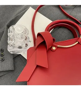 Top view of red leather bucket bag featuring a large bow and gold metal ring handle