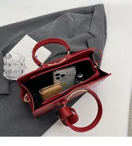 Top view of red leather bucket bag interior showing spacious storage and golden handle