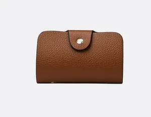 Close-up of brown litchi pattern leather wallet with a golden metal snap closure