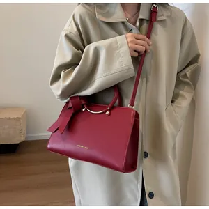 Detail of red leather bucket bag with large bow and Fashion & Bags text on side view