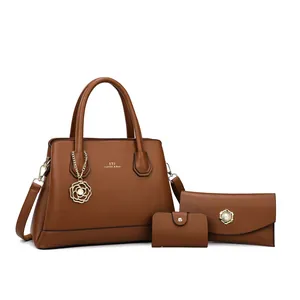 Three-piece brown faux leather tote set with crossbody bag, wallet, and pearl charm