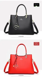 Detail view of black and red PU leather handbags with heart pendants and golden hardware