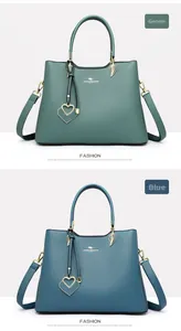 Detail of green and blue PU leather handbags with golden leaf hardware and heart charms