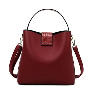Vista frontale di una borsa rosso vino con motivo litchi e dettagli in coccodrillo