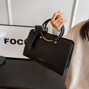 Elegant black bucket bag with a large bow and gold metal handle for women