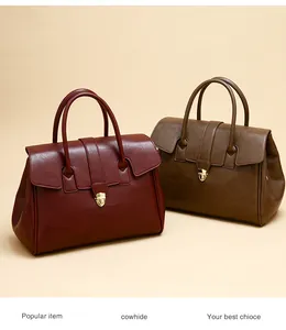 Detail of vintage cowhide tote bags in burgundy and olive with gold shield buckle