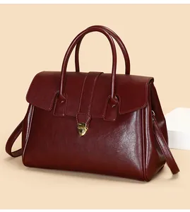 Detailed close-up of dark wine red tote bag with golden heart clasp and pebble texture