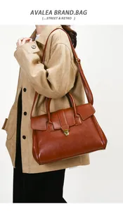 Close-up of caramel brown vintage tote bag featuring a gold metal buckle and sturdy handle