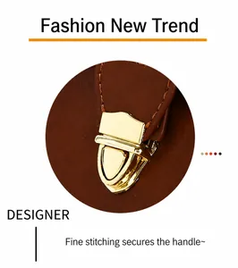 Detail of vintage brown leather bag with gold shield buckle and reinforced stitching