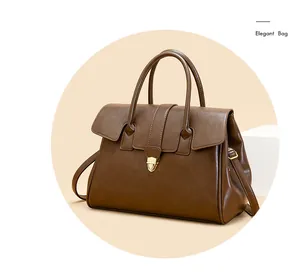 Detail of vintage brown tote bag featuring elegant golden metal clasp and leather texture