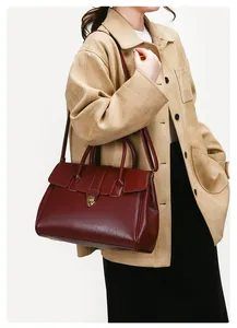 Detail of burgundy leather tote showing the gold shield lock and smooth textured finish
