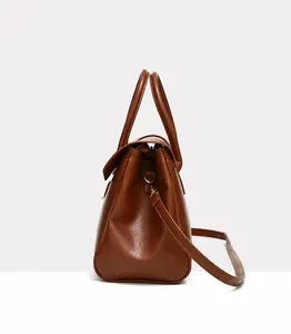 Side view of brown pebbled leather tote bag showing zippers and slim shoulder strap