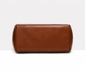 Close-up of the vintage caramel brown tote bag bottom showing fine stitching and leather texture