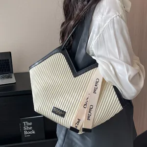 Large cream canvas tote bag with black trim and pleated texture for daily commute