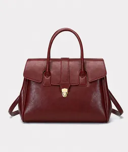 Macro shot of wine red textured leather handbag with elegant gold metal buckle