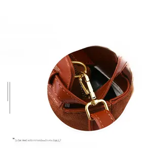 Detailed close-up of golden metal buckle on brown leather patchwork shoulder bag