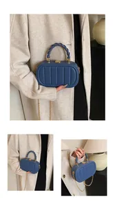 Detail showing blue square bag with vertical texture and golden chain strap