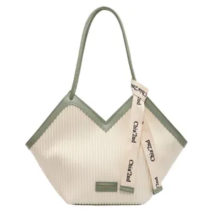 Women's off-white corduroy tote bag with green leather trim and shoulder straps