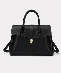 Detail of black pebbled leather handbag with elegant gold buckle and sturdy handle