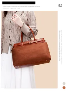Close-up of brown suede tote bag featuring a leather decorative strap and metal buckle