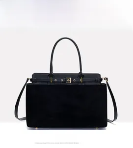 Detail of black matte suede tote bag featuring golden buckle and bottom metal studs