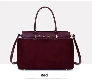 Detail of burgundy leather tote featuring a matte suede texture and gold buckle design