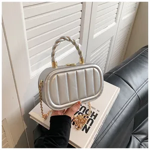 Silver quilted crossbody bag featuring a golden chain strap and woven top handle detail