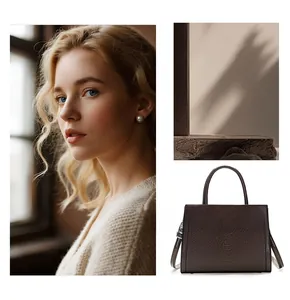 Detail of dark brown crocodile embossed leather handbag with silver metallic turn-lock