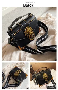 Detail of black lychee grain leather bag with gold rivets and lion head buckle decoration