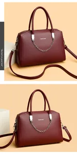 Detailed macro view of burgundy lychee leather handbag with silver chain and brand logo
